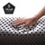 A hand presses into the Malouf Zoned Dough + Bamboo Charcoal’s dark, perforated foam—perfect with a bamboo charcoal pillow. A black pentagon badge in the corner shows "5 YEAR WARRANTY" on a clean white background. Brand: Malouf.